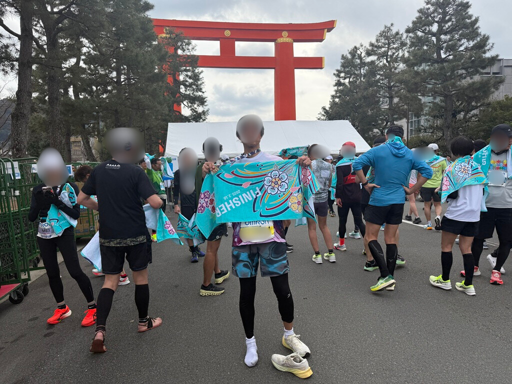 京都マラソンメダルとタオル。やはり脱いでいる右足のシューズが痛々しい